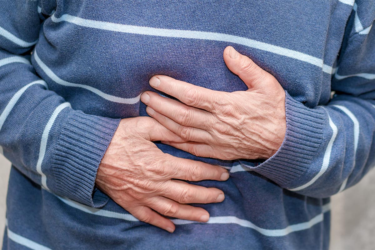 male wrinkled hands holding sick stomach health care concept