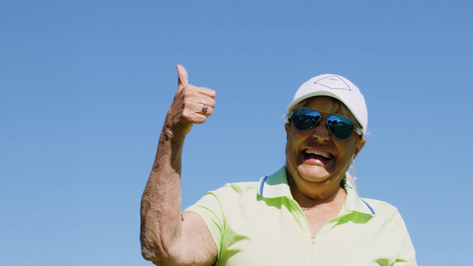Linda, LR-MDS patient, smiling with thumbs up on golf course