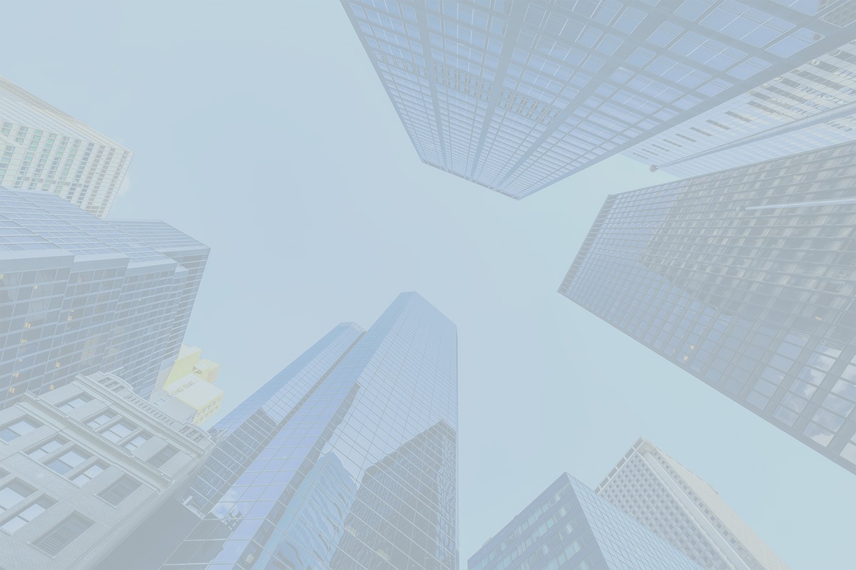 Looking up at modern glass skyscrapers towering against a clear blue sky