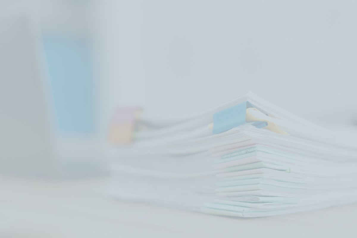 Medical charts and patient files with colorful index tabs stacked on a desk